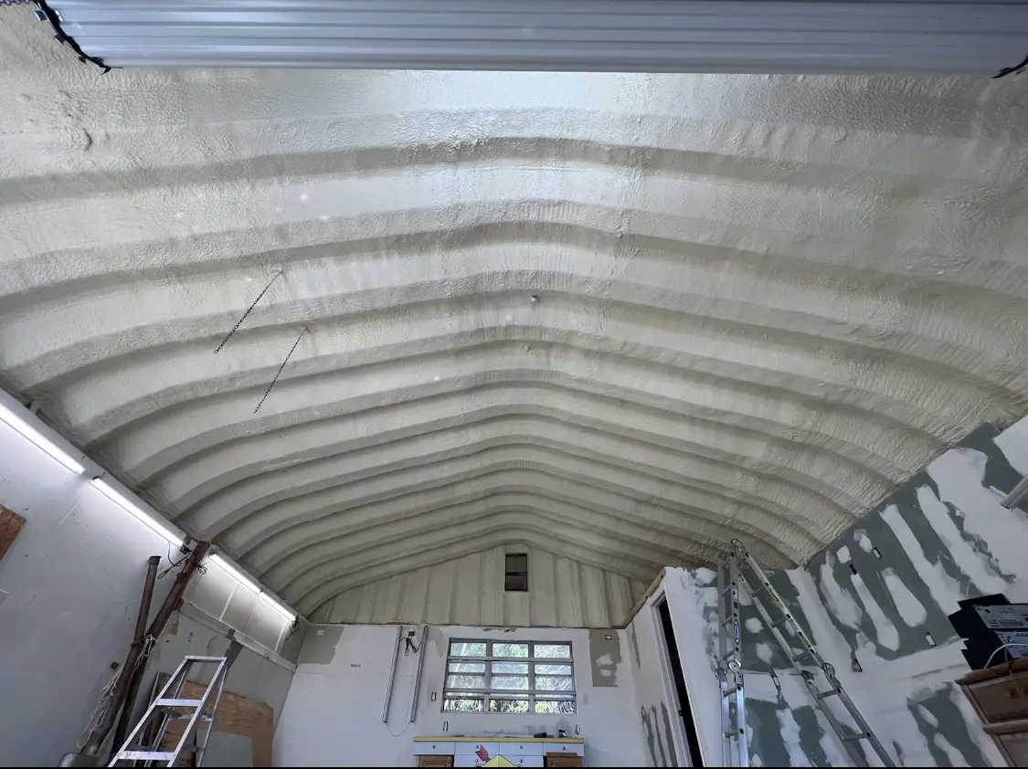 Spray polyurethane foam applied to the underside of a metal roof deck in Geddes